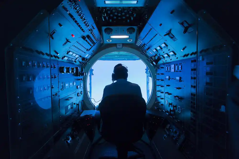The pilot at the controls with the forward dome viewport ahead