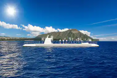 The submarine on the surface with Diamond Head and the Honolulu skyline behind it